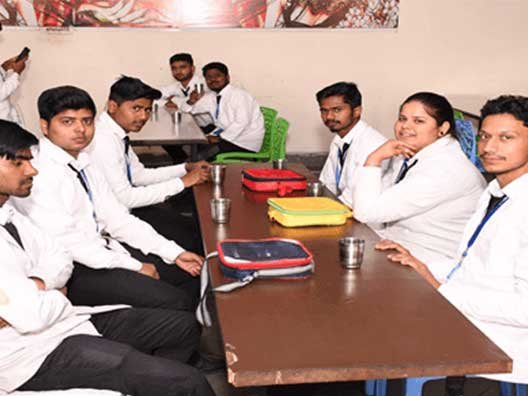 pharmacy-students-in-white-lab-coats-sitting-together-in-the-college-canteen